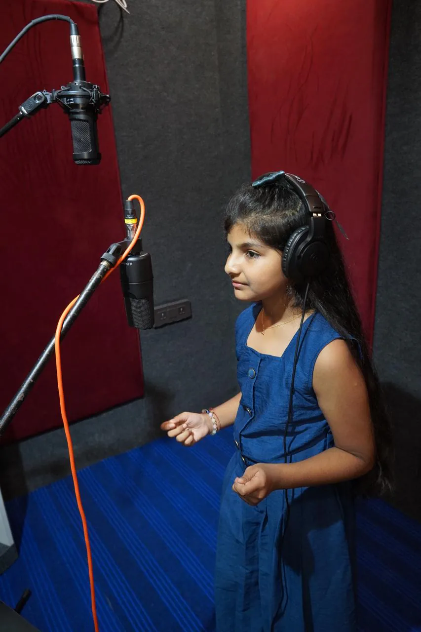 Young student recording vocals with headphones and studio microphones